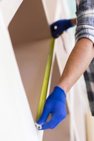 man-using-tape-measure-wall